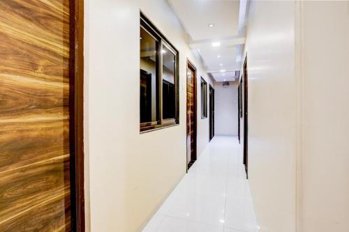 a hallway with white walls and wooden doors at Super Collection O Airport Metro Andheri East in Mumbai