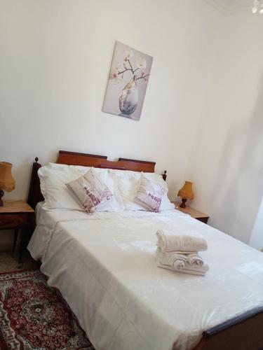 a bedroom with a bed with white sheets and pillows at Casa Vacanza Arzello in Melazzo