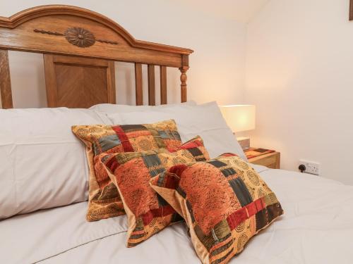 a bed with a wooden headboard and a pillow on it at Lane End in South Molton