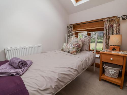 a bedroom with a bed and a desk and a window at Lane End in South Molton
