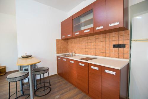 a kitchen with a sink and two stools at Apartments Hari in Supetarska Draga