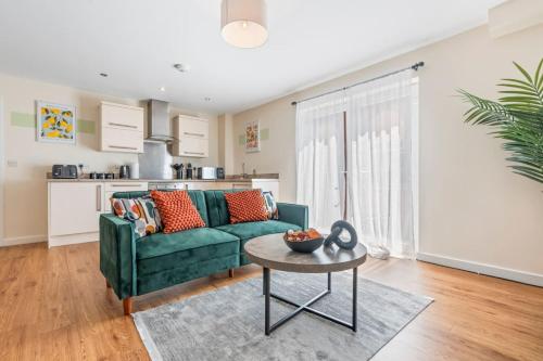 a living room with a green couch and a table at Spacious 3-Bed Flat, Sleeps 7, Ideal for Families, Central Location, High-Speed Internet in Leicester