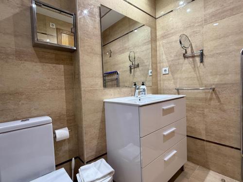 a bathroom with a toilet and a sink and a mirror at Reinapart Patacona Beachfront Seaview in Valencia