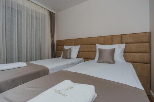 two beds sitting next to each other in a room at Conchiglia Apartments in Sveti Stefan