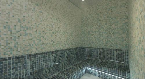 a bathroom with a bath tub with tiled walls at Crowne Plaza Constanta - Mamaia Beach by IHG in Mamaia