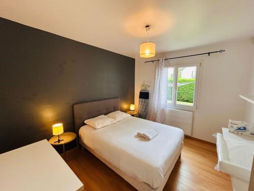 una camera da letto con un letto bianco e una finestra di La Villa du vignoble Piscine a Hermonville