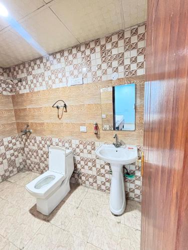 a bathroom with a toilet and a sink at Nivasa-Crafted with love in Ghaziabad