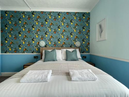 a bedroom with a large bed with a blue wall at Wedgwood Hotel - Room 7 in Llandudno