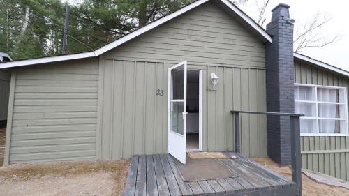 a small gray building with a white door at Algonquin Lakeside Inn in Dwight
