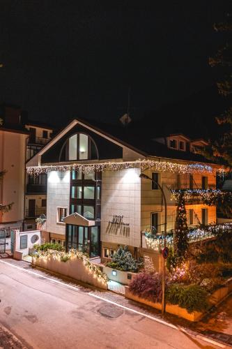 a house decorated with christmas lights and a christmas tree at Hotel Petite Fleur in Roccaraso