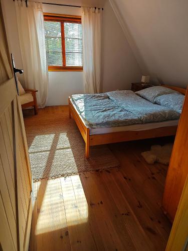a bedroom with a bed and a window at Domek na Kaszubach w Pomysku Małym in Soszyca