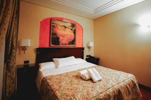 a bedroom with a bed with two towels on it at Hotel Petite Fleur in Roccaraso