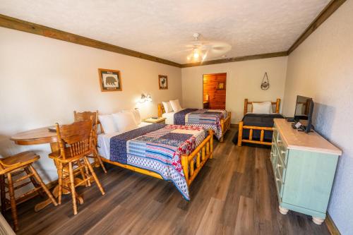 a room with two beds and a table and a desk at Fishtale Lodge in Buchanan