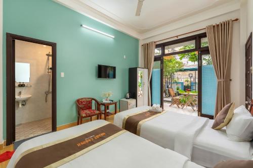 a hotel room with two beds and a patio at Smart Garden Homestay in Hoi An
