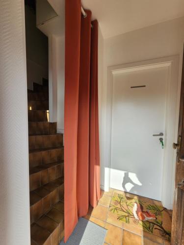 a hallway with orange curtains next to a staircase at MIN HISELE, Ma PETITE MAISON in Lingolsheim