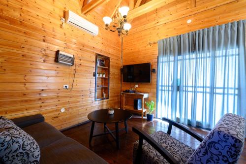 a living room with a couch and a table at בקתות בצל הגפן in Goren