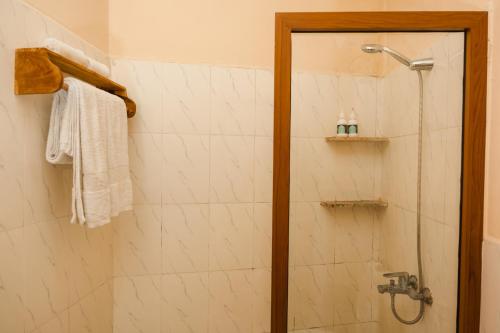a shower with a glass door in a bathroom at Emerald Palm Boutique Hotel in Zanzibar City