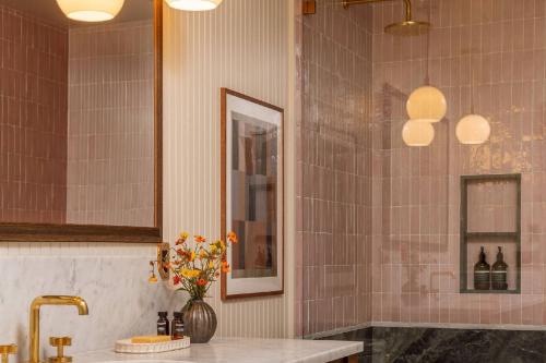 a bathroom with a sink and a vase of flowers at The Carly Estate in Carlton