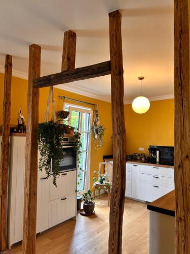 a kitchen with wooden posts in a kitchen with yellow walls at Gemütliches Dachzimmer mit Kamin in Andernach