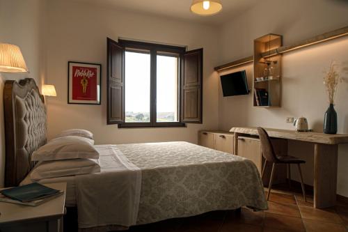 a bedroom with a bed and a table and a window at Agriturismo Emidio Pepe in Torano Nuovo