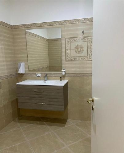 ein Badezimmer mit Waschbecken und Spiegel in der Unterkunft Corte Vena Palace in Bianco
