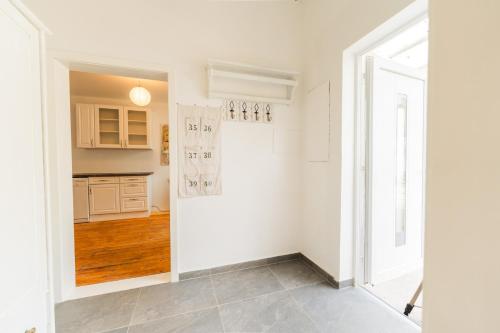 a kitchen with white walls and wooden floors at Wohnung am Pferdehof in Pressbaum