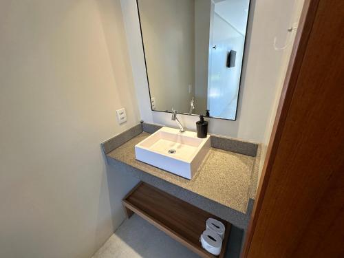 a bathroom with a white sink and a mirror at Parador Casa da Praia in Torres
