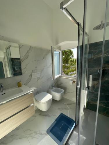 a bathroom with a toilet and a sink and a shower at Casa lumiére in Bisceglie
