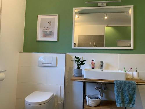 Un baño con un lavabo blanco y un espejo. en FeWo Auszeit, en Frensdorf