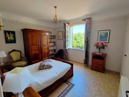 a bedroom with a bed and a window at L'Enclos du Château in Courthézon