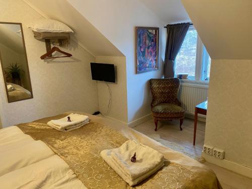 a bedroom with a bed with two towels on it at Pensionat Kanalvillan in Väddö