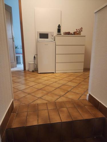 a kitchen with a tile floor and a microwave at MIN HISELE, Ma PETITE MAISON in Lingolsheim