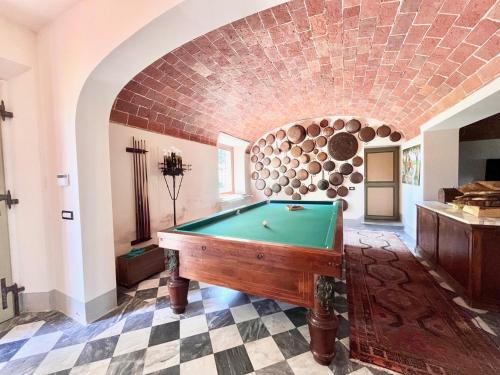 a pool table in a room with a brick wall at Agriturismo La Palazzina in Palaia
