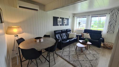 a living room with a table and a couch at Sentrumsnær sokkelleilighet in Bardu
