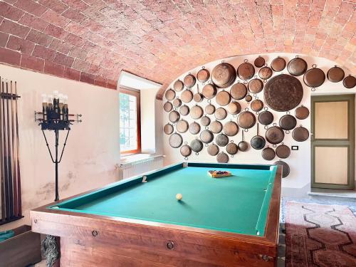 a pool table in a room with a brick wall at Agriturismo La Palazzina in Palaia
