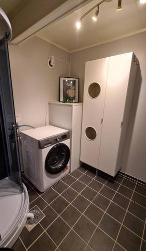 a washer and dryer in a small bathroom at Sentrumsnær sokkelleilighet in Bardu