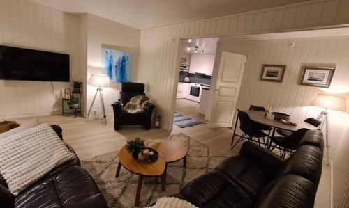 a living room with a couch and a table at Sentrumsnær sokkelleilighet in Bardu