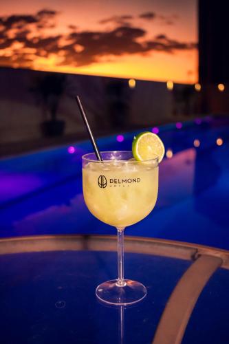a drink sitting on a table with a slice of lime at Delmond Hotel in Cuiabá
