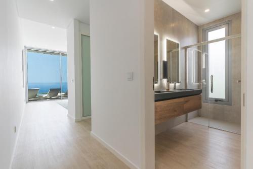a bathroom with a sink and a view of the ocean at Villa Alegria by Atlantic Holiday in Calheta