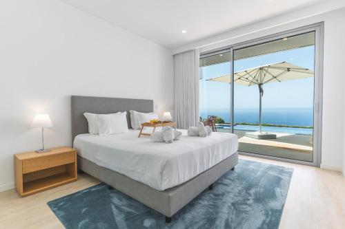 a bedroom with a large bed and a large window at Villa Alegria by Atlantic Holiday in Calheta