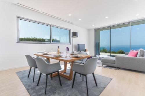 a dining room with a table and chairs and a couch at Villa Alegria by Atlantic Holiday in Calheta