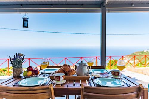 a table with food and glasses of wine on a balcony at Casa D'Avó Bela in Arco da Calheta