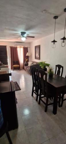 a living room with a table and chairs and a couch at Alojamiento cómodo en Cancún in Cancún