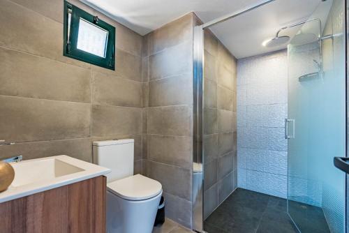 a bathroom with a toilet and a shower at Casa D'Avó Bela in Arco da Calheta