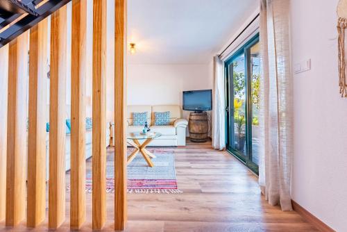 a living room with a couch and a tv at Casa D'Avó Bela in Arco da Calheta