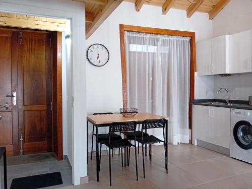una cocina con mesa y sillas y un reloj en la pared en Casa Padie, en La Orotava