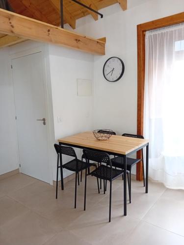 Una mesa de comedor con sillas y un reloj en la pared. en Casa Padie, en La Orotava