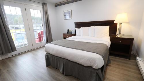a hotel room with a large bed and a window at Algonquin Lakeside Inn in Dwight