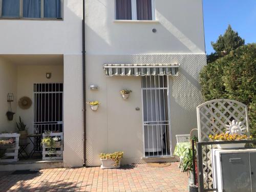 a white house with a door and a patio at Casa Laura a due passi dal mare in Rimini
