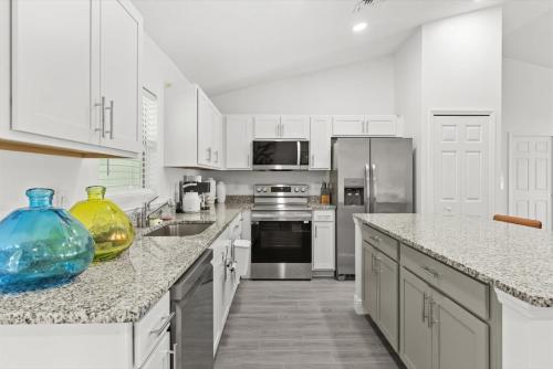 a kitchen with white cabinets and stainless steel appliances at Coosa Dr in Port Saint Lucie